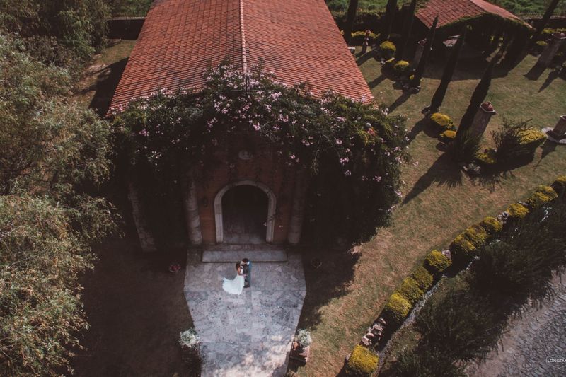 Bride and groom embracing outside a romantic villa wedding venue surrounded by trees and gardens