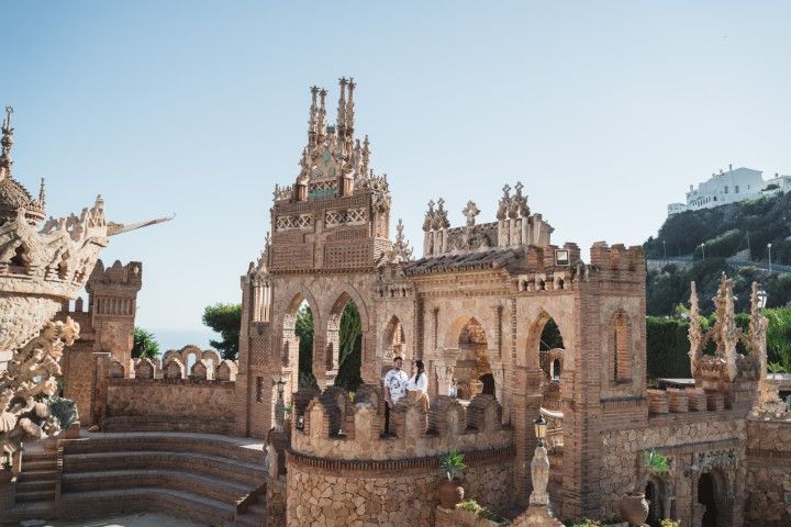 Couple standing inside Castillo Colomares in Benalmádena with ornate stone architecture and sea views