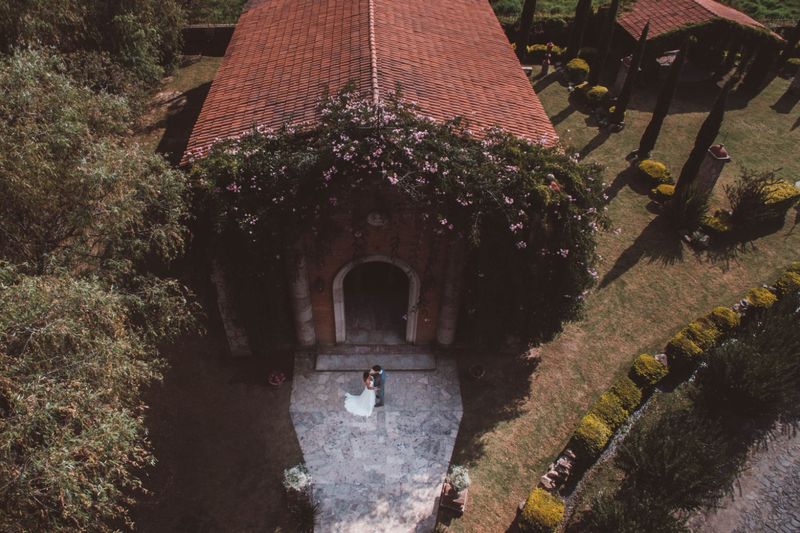 Bride and groom embracing outside a romantic villa wedding venue surrounded by trees and gardens