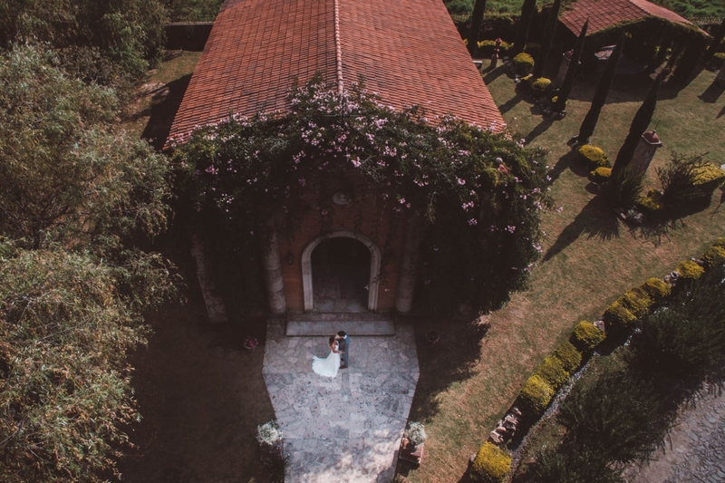 Bride and groom embracing outside a romantic villa wedding venue surrounded by trees and gardens