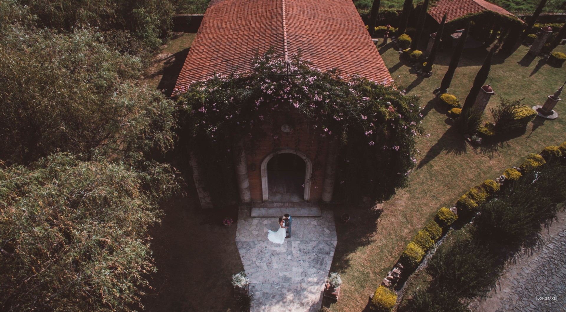 Bride and groom embracing outside a romantic villa wedding venue surrounded by trees and gardens