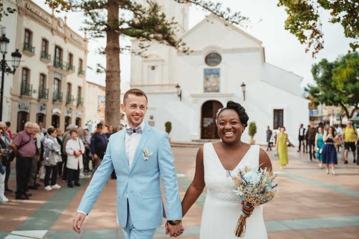 Newly married couple walking through a town square after a civil wedding ceremony in Andalusia