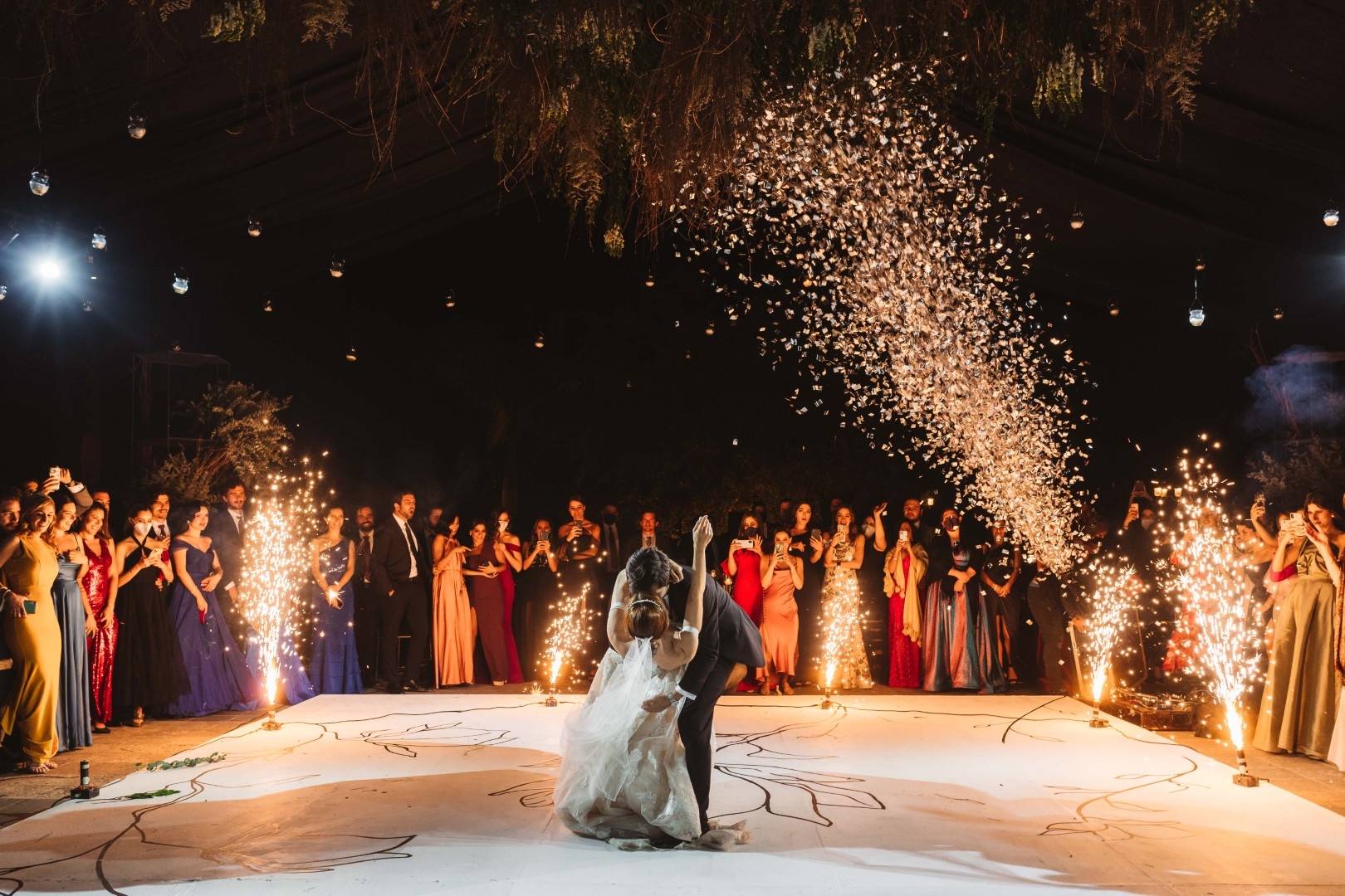 Bride and groom sharing their first dance beneath confetti and lights at a Marbella wedding celebration