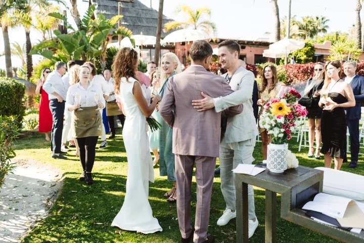 Bride and groom exchanging vows during an outdoor wedding ceremony overlooking the coast near Marbella
