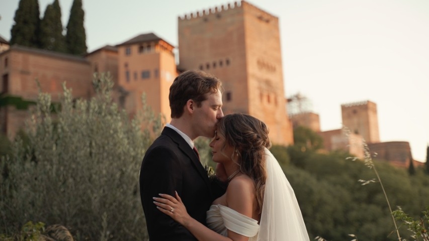 Bride and groom at Carmen de los Chapiteles in Granada with the Alhambra glowing at sunset behind them