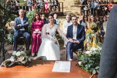 Wedding ceremony beneath a canopy of trees with guests seated behind the couple in southern Spain