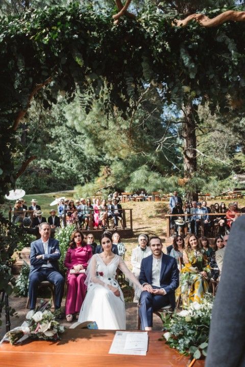 Wedding ceremony beneath a canopy of trees with guests seated behind the couple in southern Spain